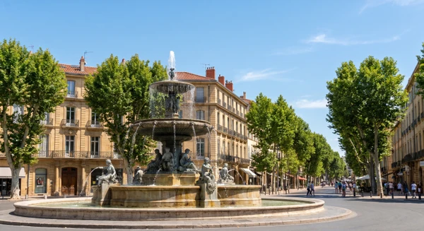 Vue urbaine d'Aix-en-Provence montrant la fontaine de la Rotonde ou un paysage architectural caractéristique de la ville (bâtiments historiques, places emblématiques) en conditions d'éclairage naturel jour. L'image doit être une photographie réelle de qualité professionnelle, sans texte ni logo.